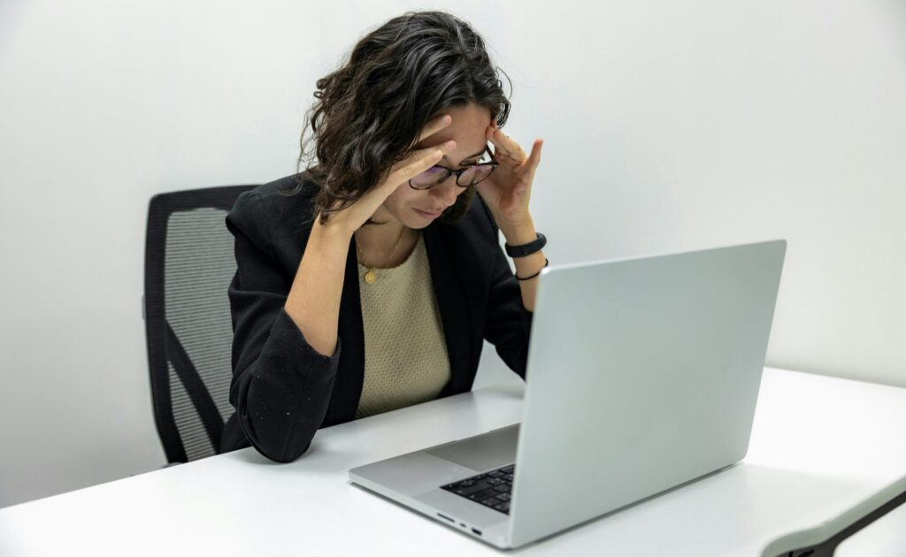 Tired Young Female Employee Feeling Stressed, Headache, and Burnout from Computer Work