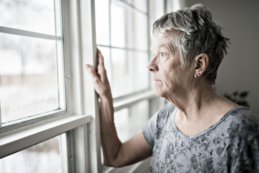 An older woman looking out the window