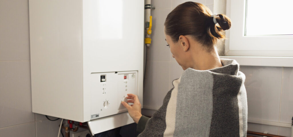 A woman reduces the power of the gas boiler in her home due to an energy crisis